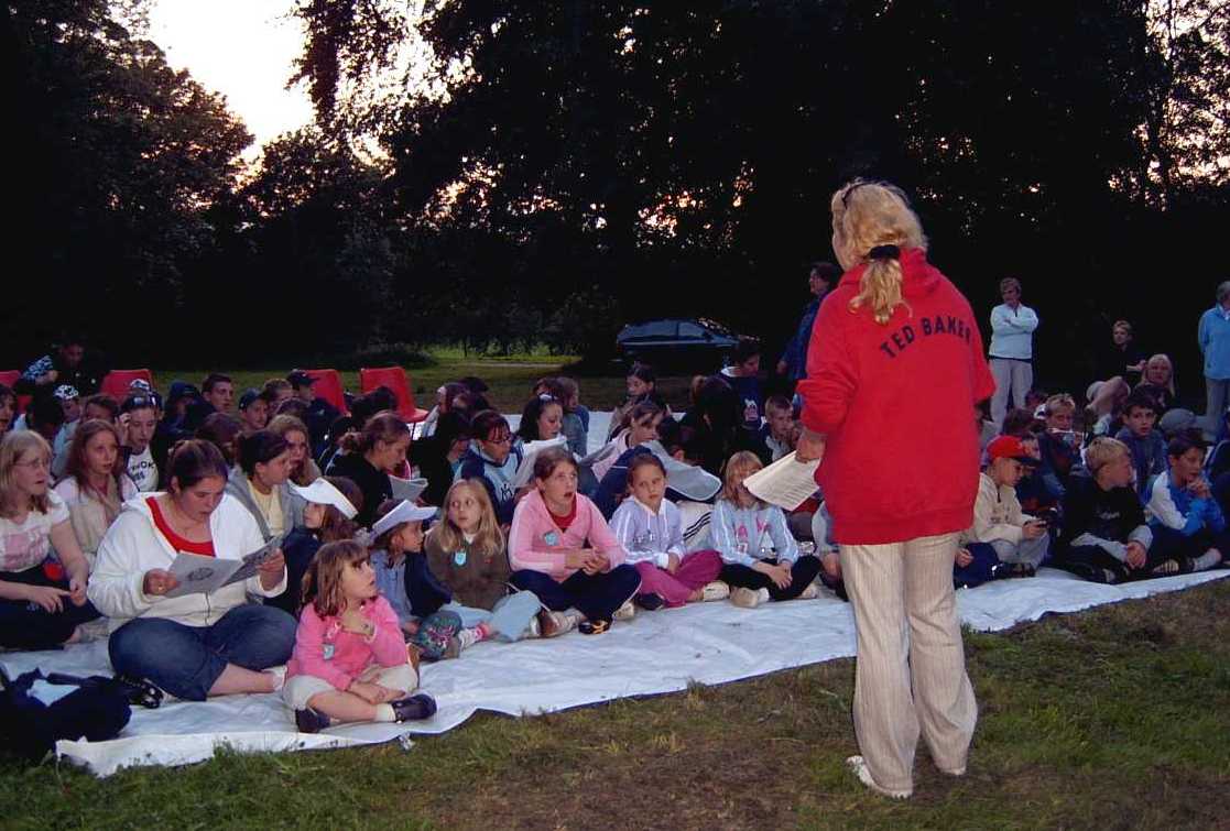 Luba leading singing at the bonfire